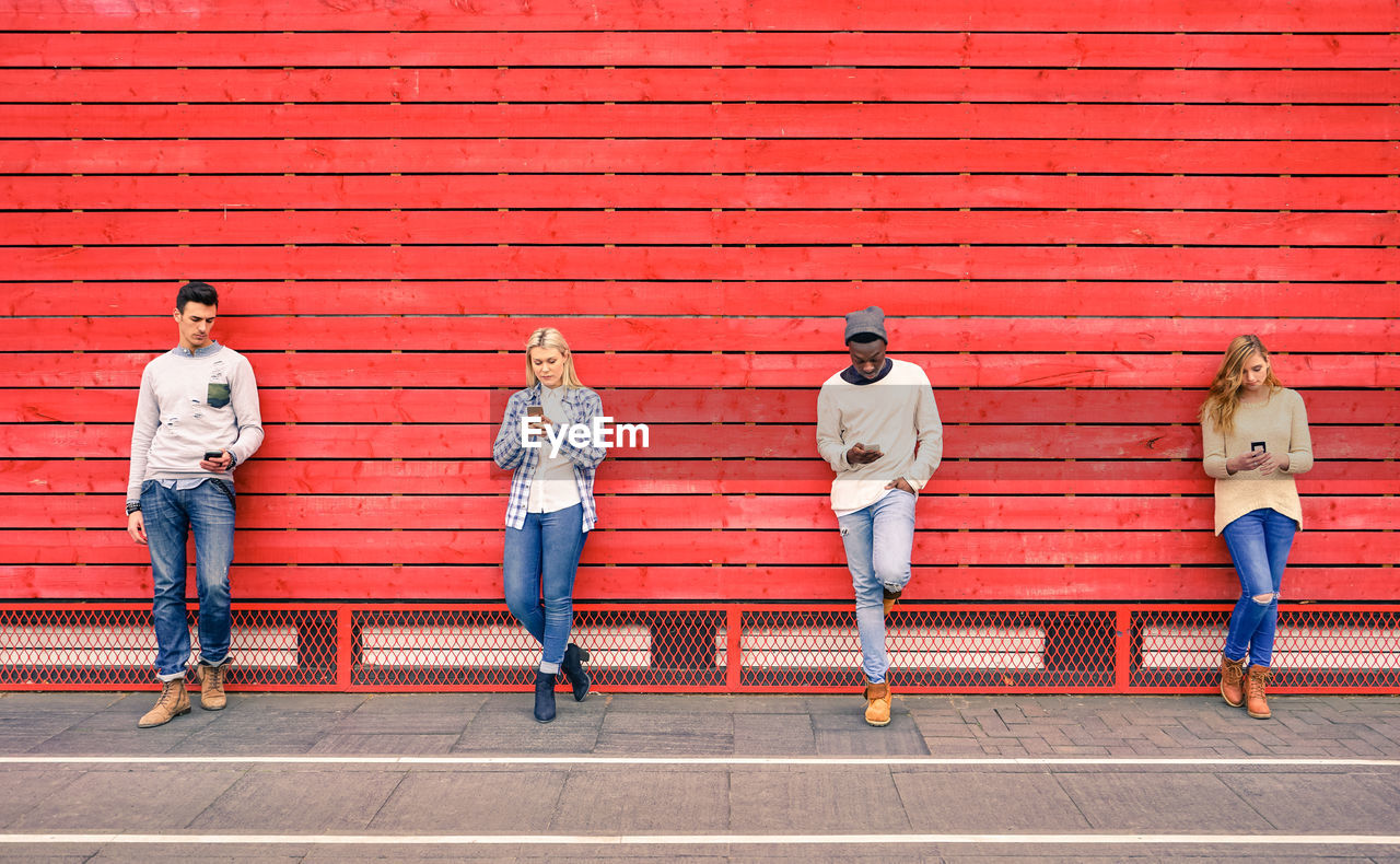 People using phones while standing on street