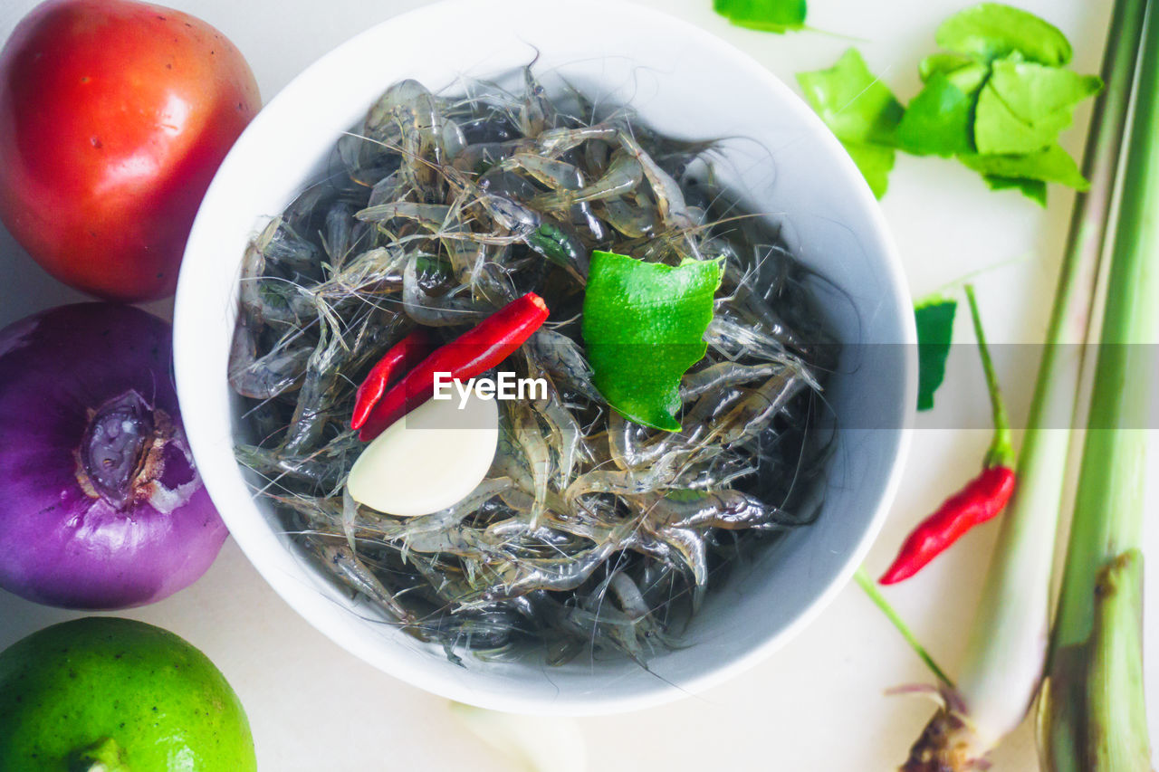 Close-up of fishes and vegetables in bowl over table