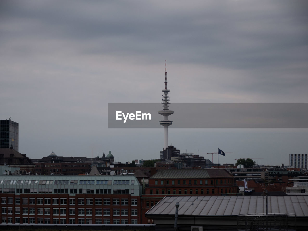 Buildings in city against cloudy sky