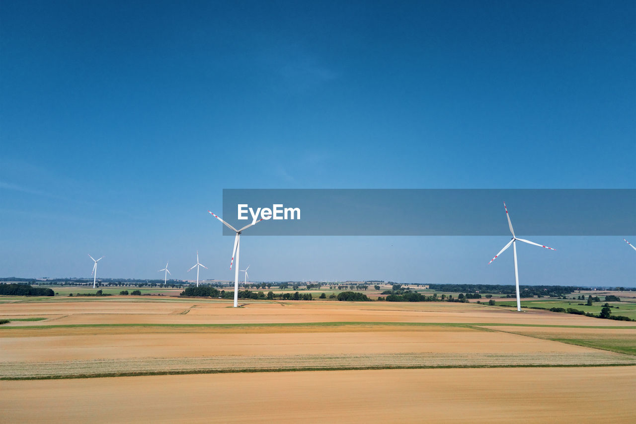 Windmill turbine in the field at summer day. rotating wind generator