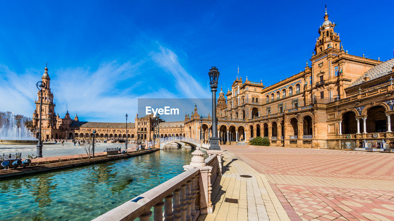 View of the building in plaza de españa against blue sky in seville, spain
