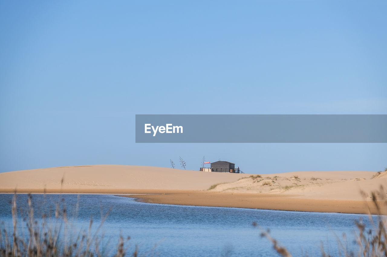 Scenic view of desert against clear blue sky