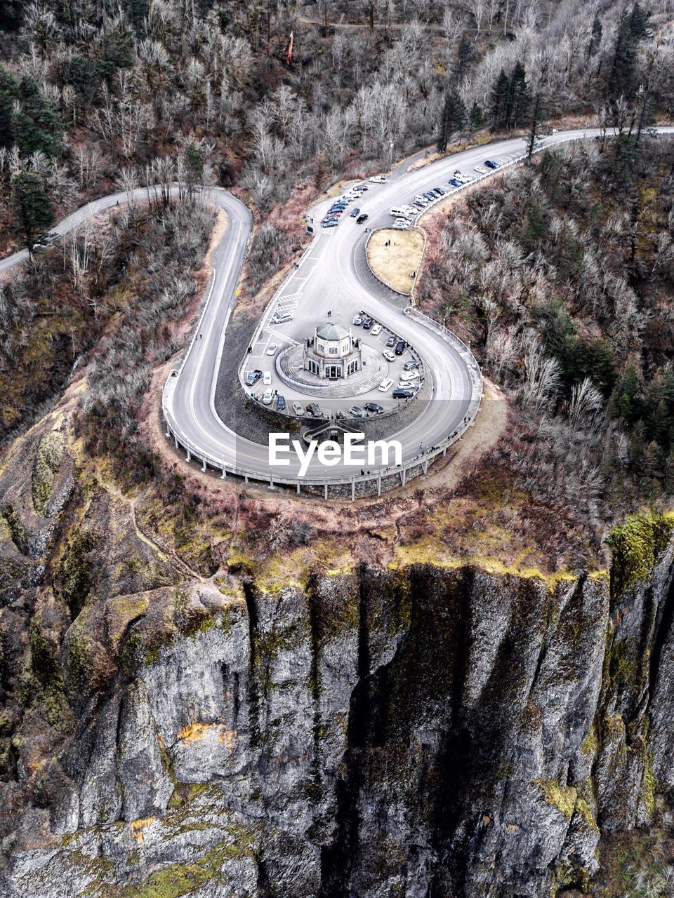 Aerial view of cars surrounding building on cliff