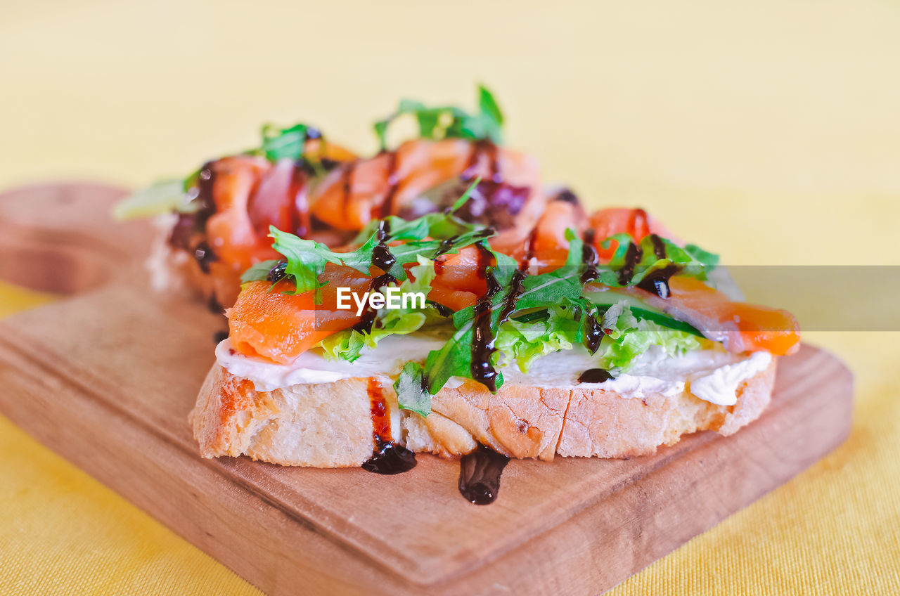 Bruschetta with salmon and sauce on a wooden board. italian cuisine. side view. 