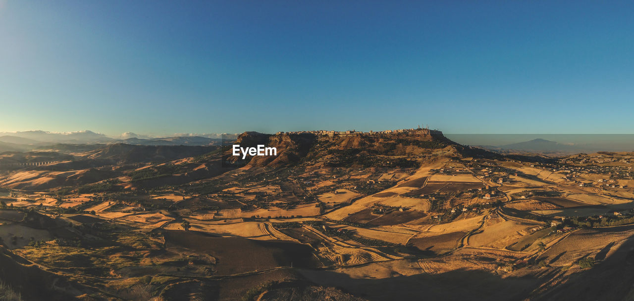 Aerial view of dramatic landscape against clear blue sky