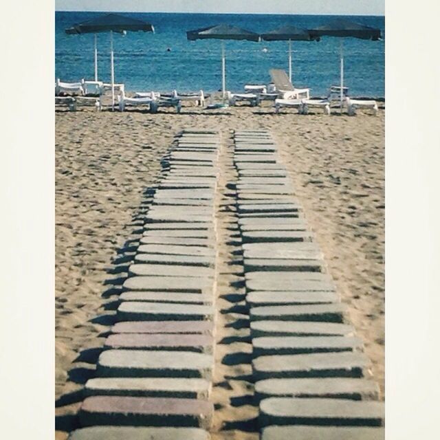 VIEW OF EMPTY BEACH WITH SEA IN BACKGROUND