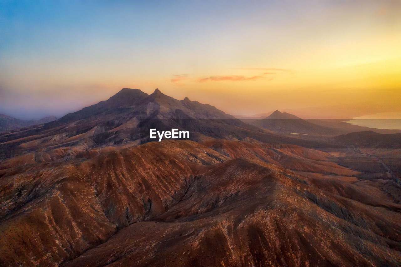 Scenic view of mountains against sky during sunset