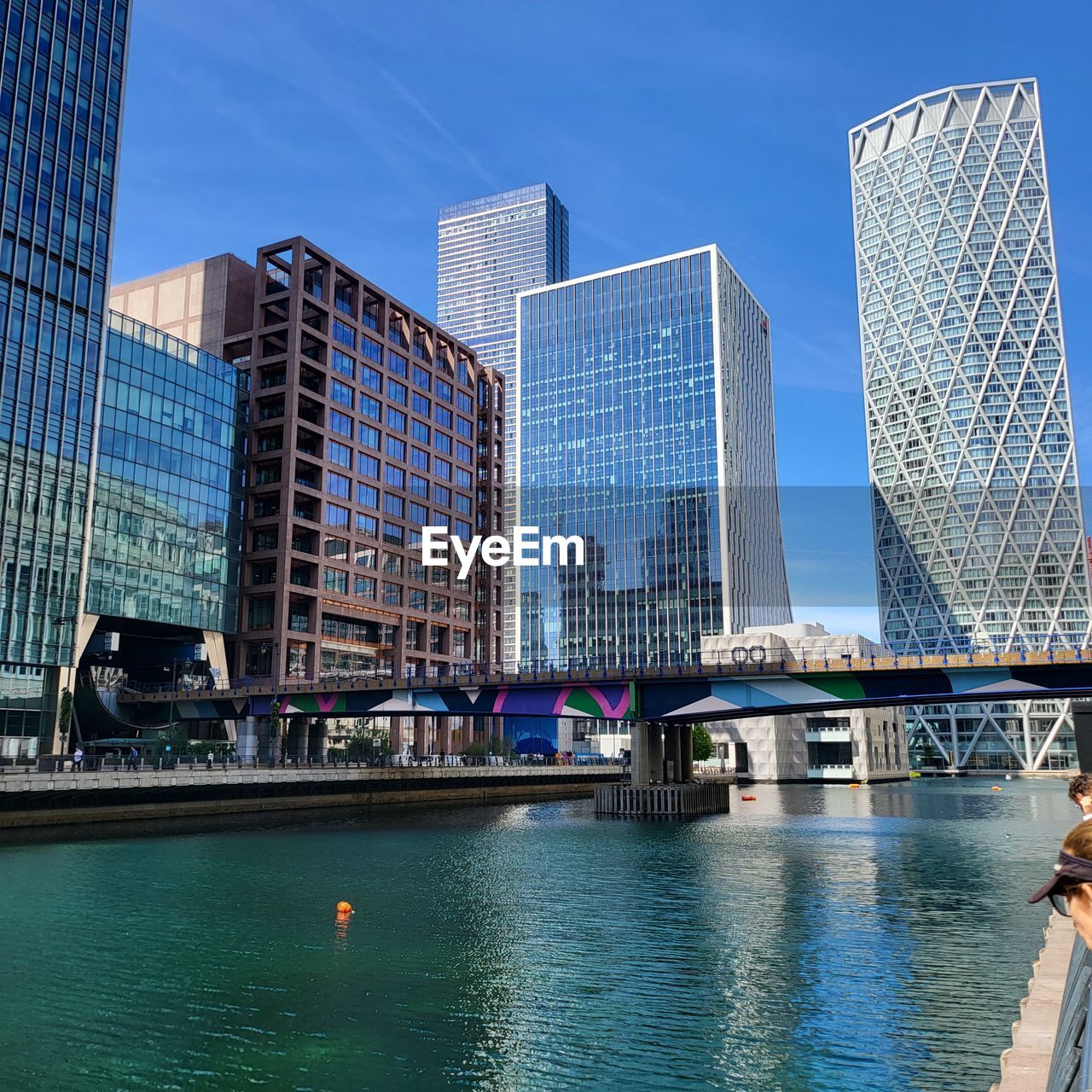 architecture, built structure, skyscraper, solar panel, solar energy, alternative energy, renewable energy, blue, power generation, sky, nature, environmental conservation, technology, building exterior, water, day, sport venue, solar power, outdoors, building, stadium, city, reflection, business