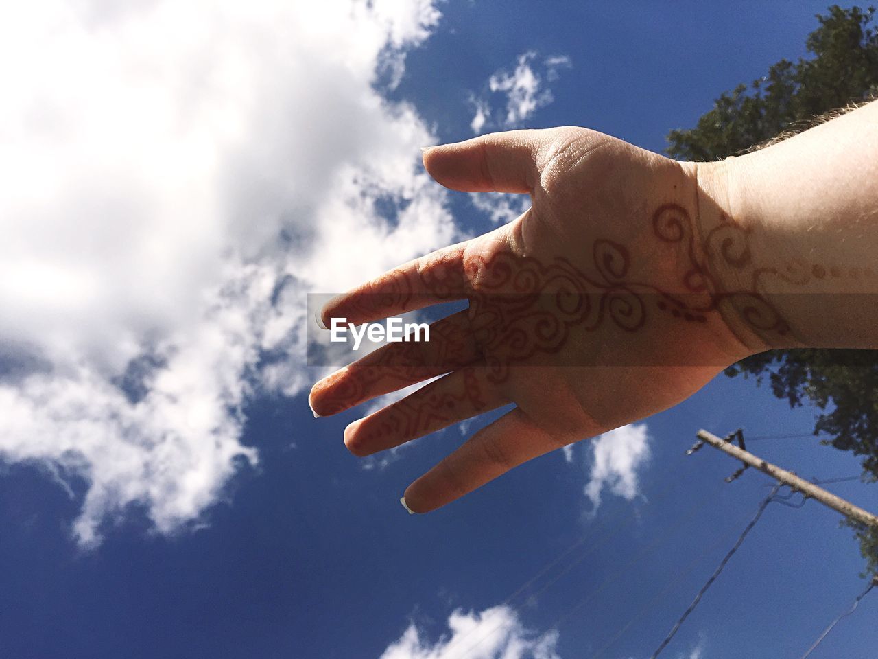 LOW ANGLE VIEW OF HANDS AGAINST SKY