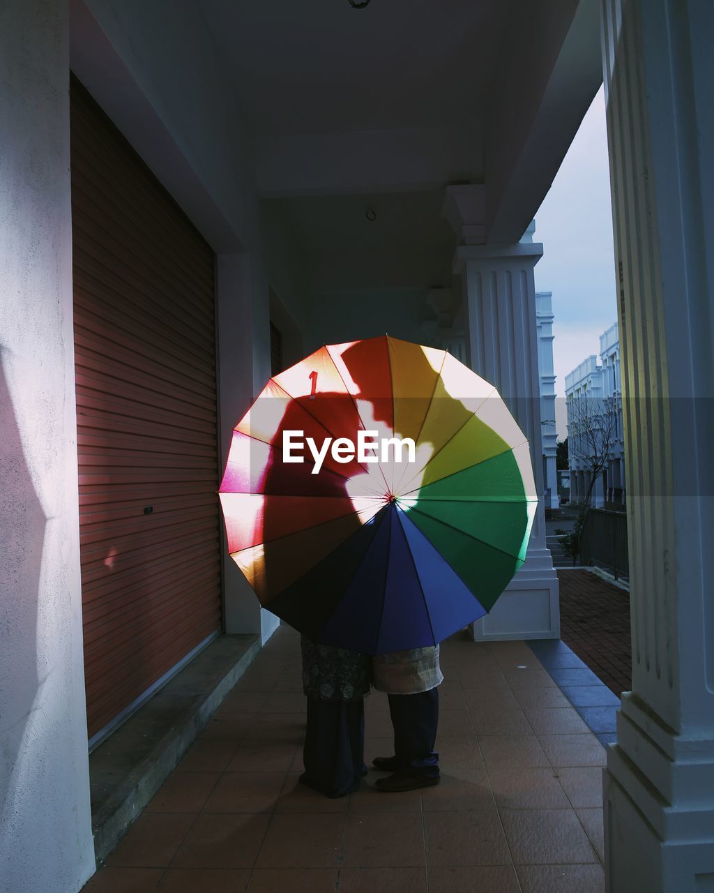 Couple standing with umbrella in building