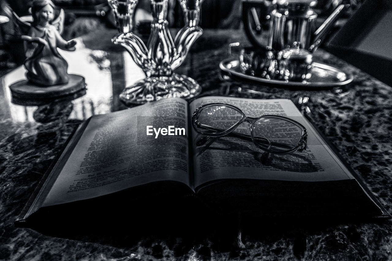 HIGH ANGLE VIEW OF EYEGLASSES ON BOOK