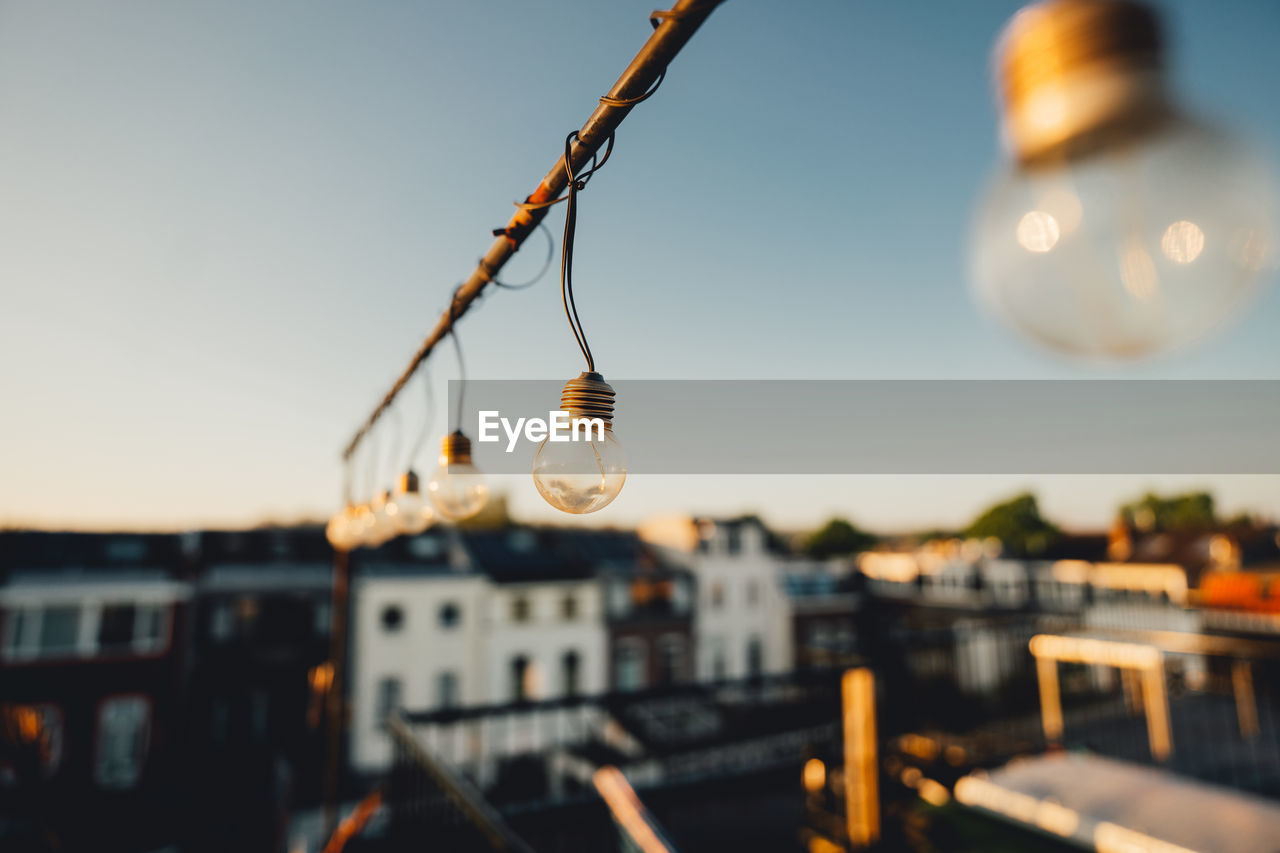 Close-up of illuminated light bulb against sky