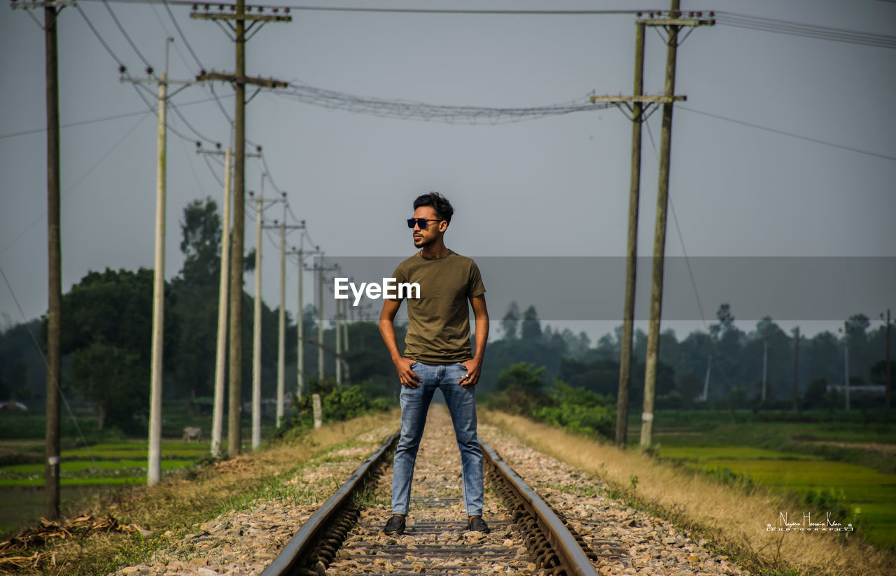 Full length of man standing on railroad track