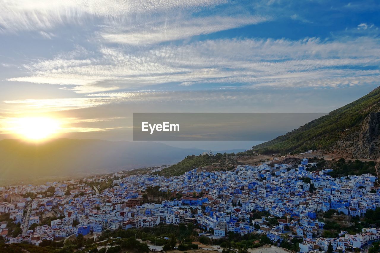 High angle view of cityscape against sea at sunset