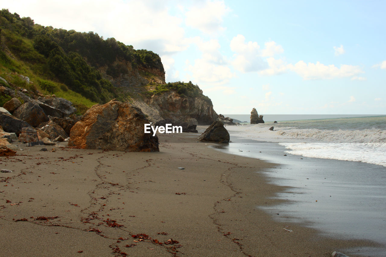 Rocks on beach against sky