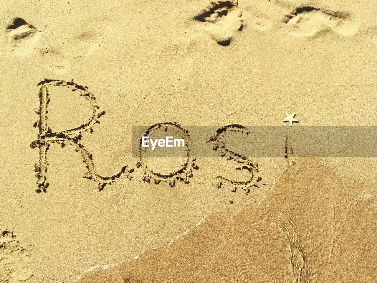 High angle view of rosi text on sand at beach