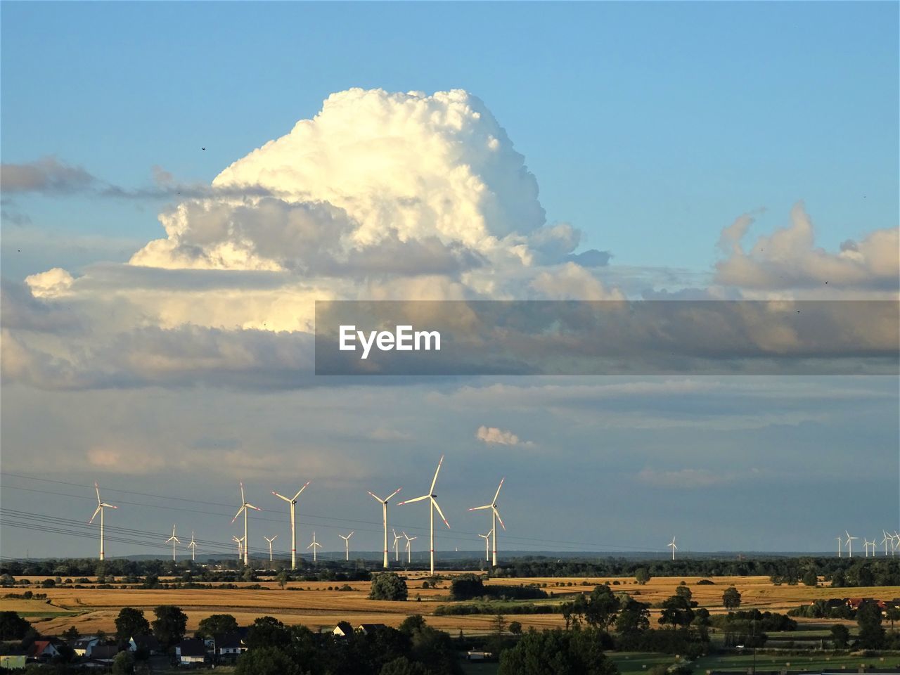 WIND TURBINES ON LAND AGAINST SKY