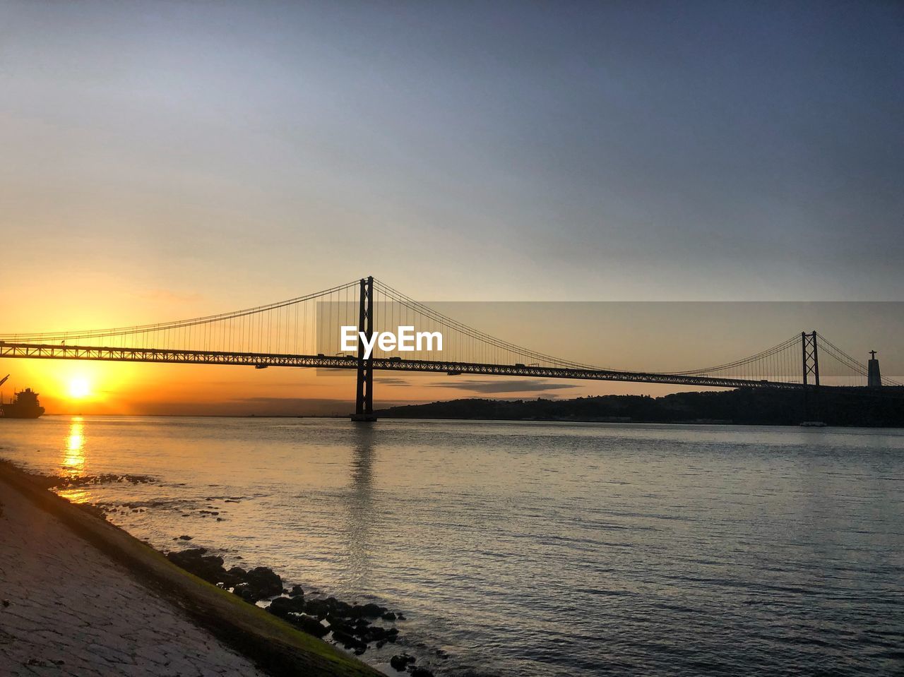 View of bridge over river at sunset