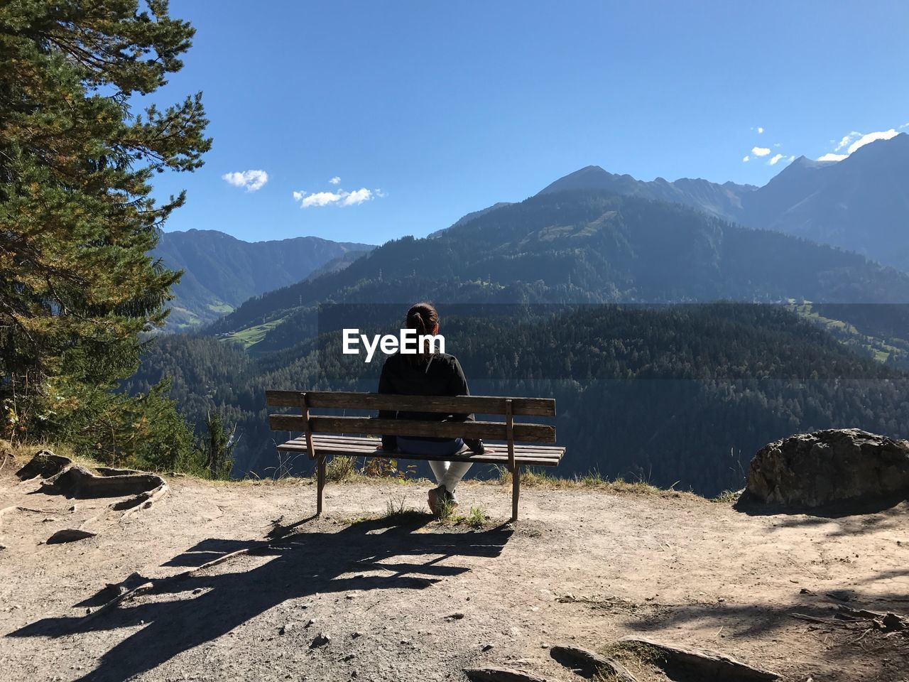 WOMAN SITTING ON CHAIR AGAINST MOUNTAIN RANGE