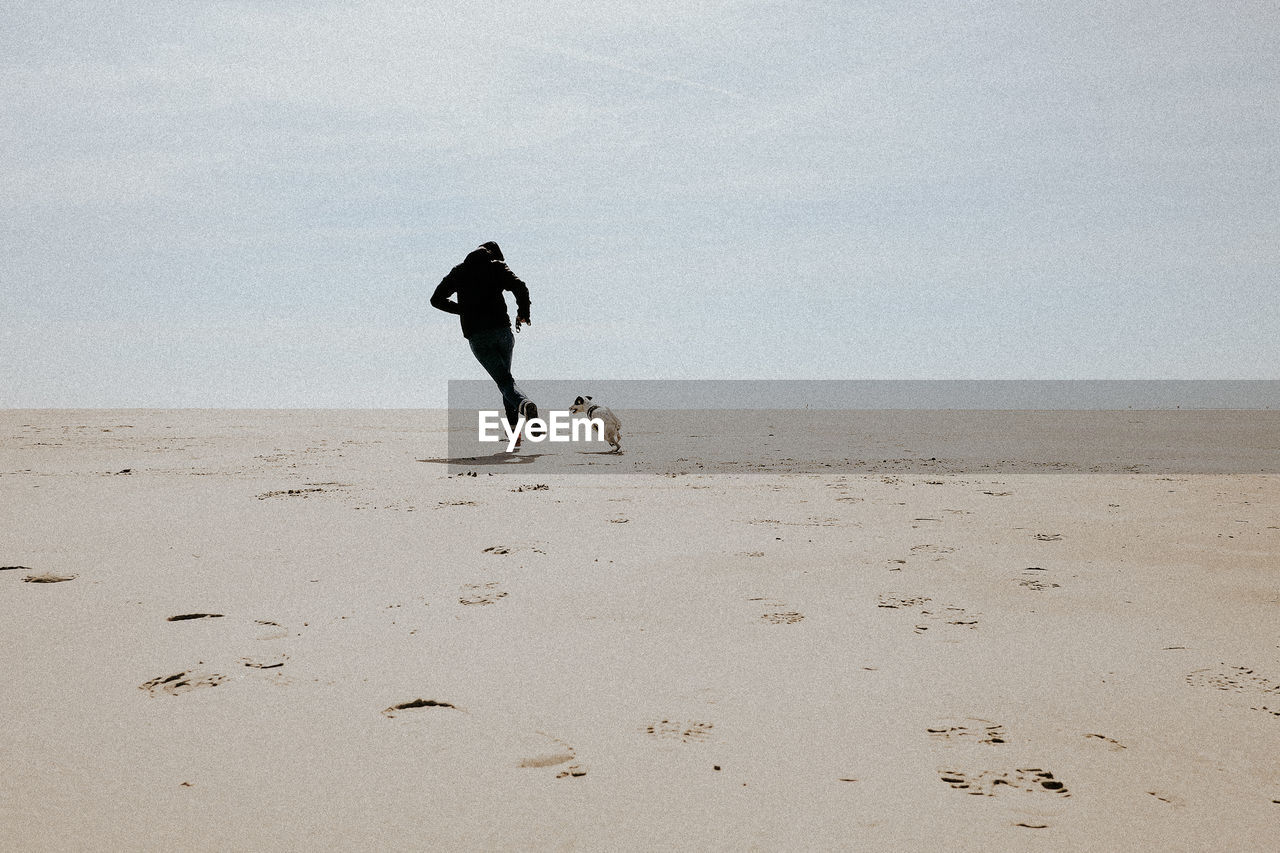 Silhouette of man on beach against sky