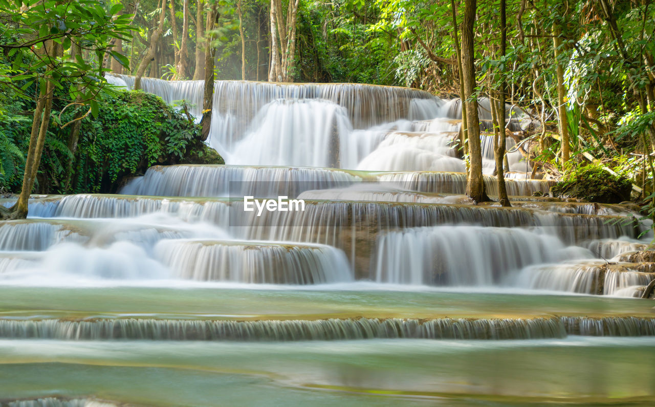 waterfall, water, beauty in nature, scenics - nature, tree, plant, environment, nature, body of water, forest, tropical climate, watercourse, water feature, motion, land, environmental conservation, travel destinations, long exposure, tourism, travel, no people, river, flowing water, outdoors, flowing, idyllic, landscape, rainforest, social issues, non-urban scene, green, water resources, stream, blurred motion, tropical tree, tranquil scene, vacation, trip, holiday