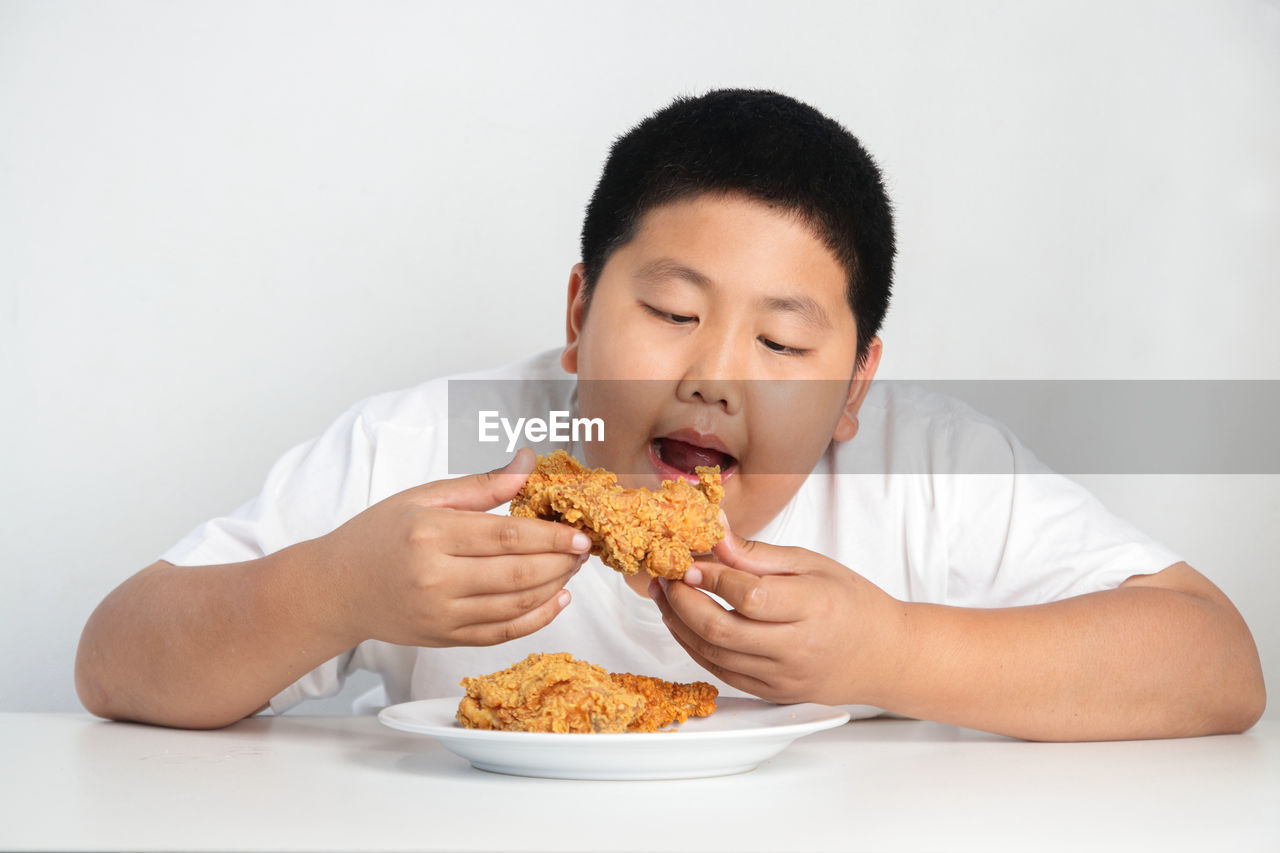 PORTRAIT OF BOY EATING FOOD