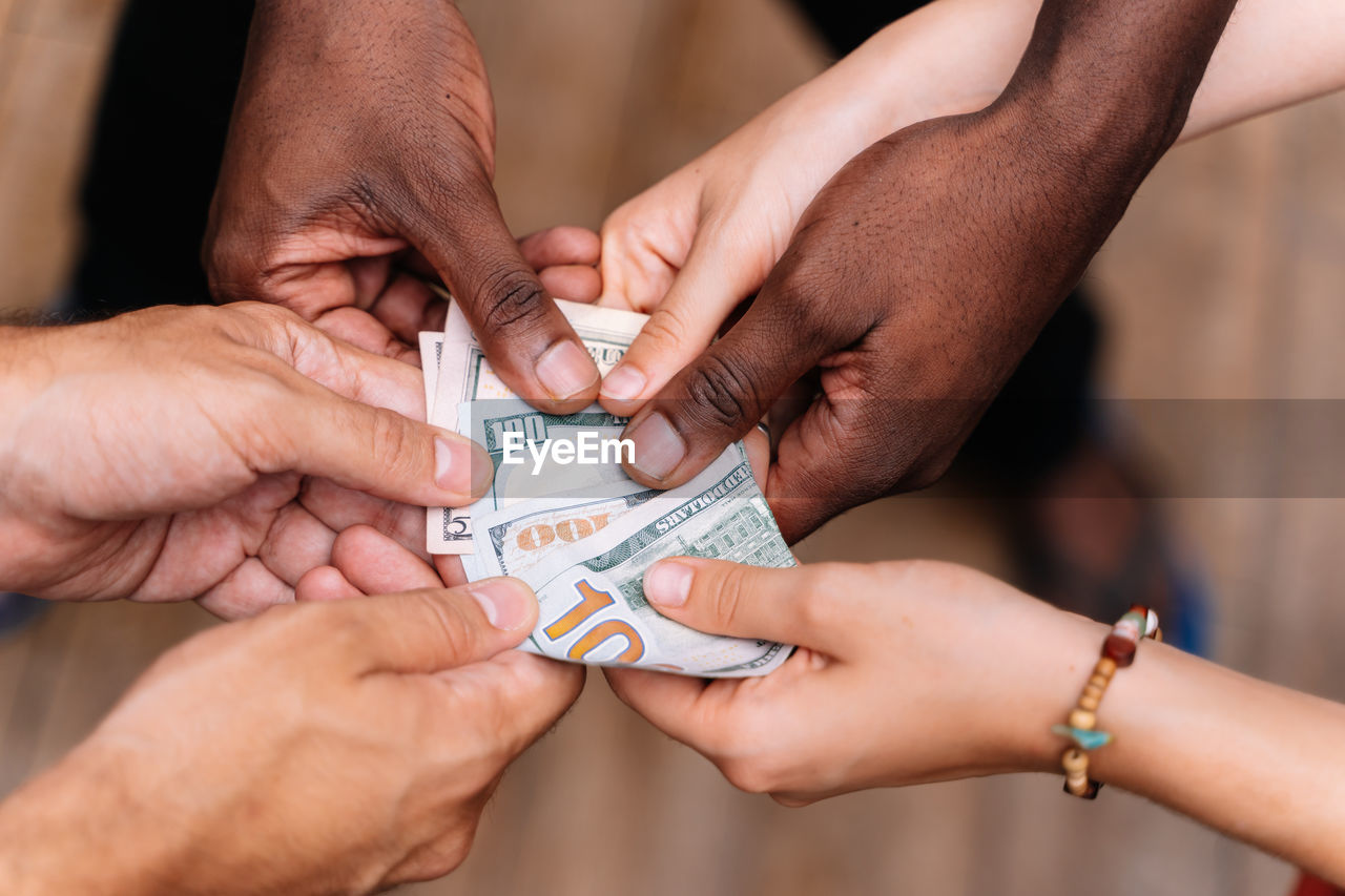 Cropped hands holding paper currencies