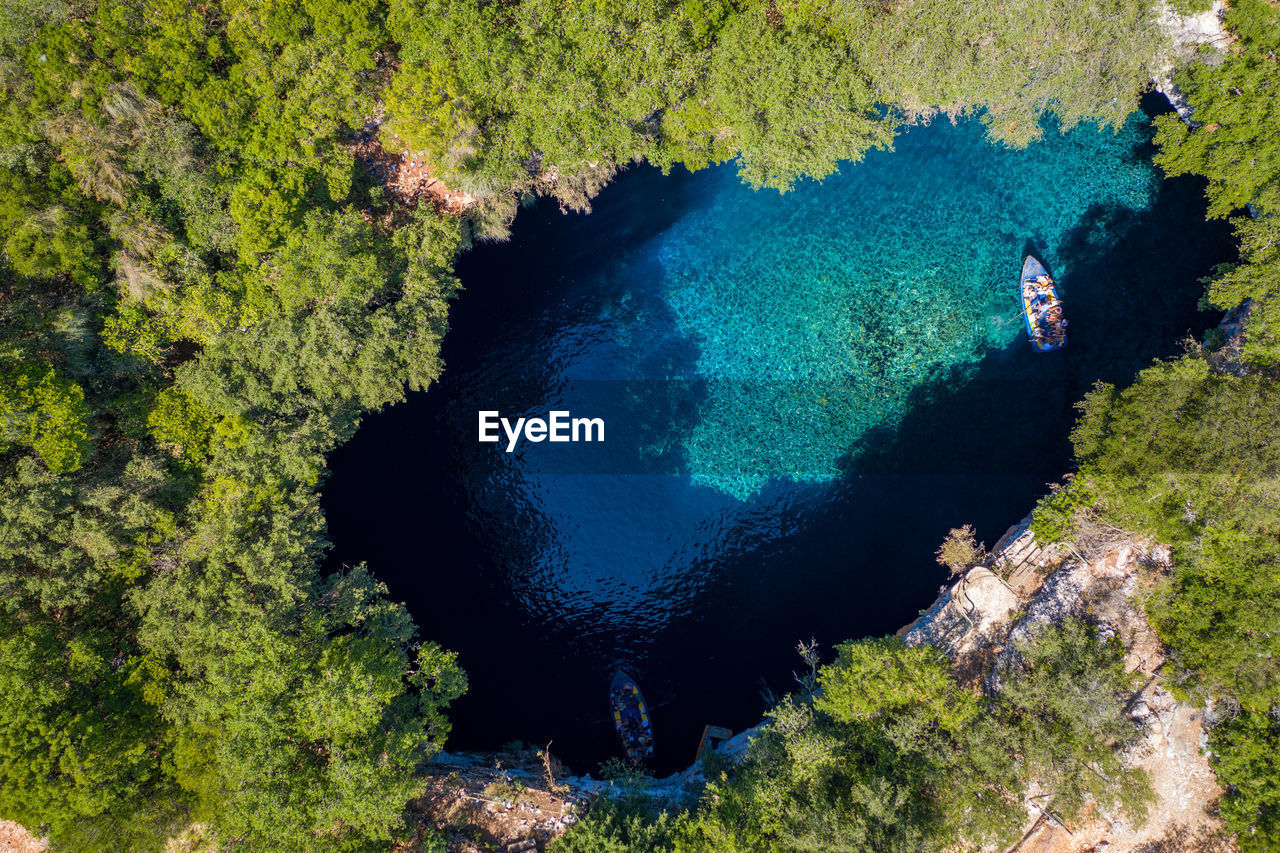 HIGH ANGLE VIEW OF TREES BY ROCKS ON SEA