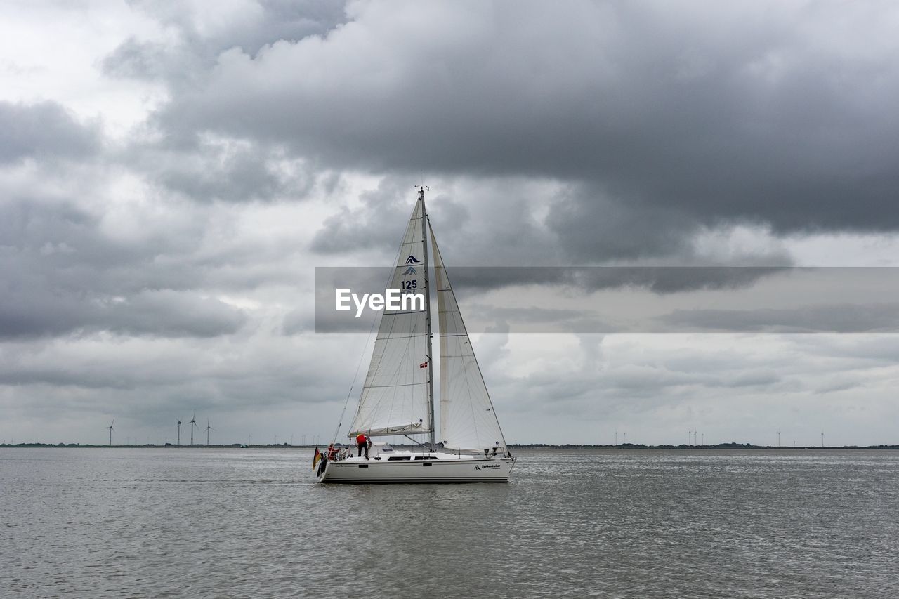 Sailboat sailing on sea against sky