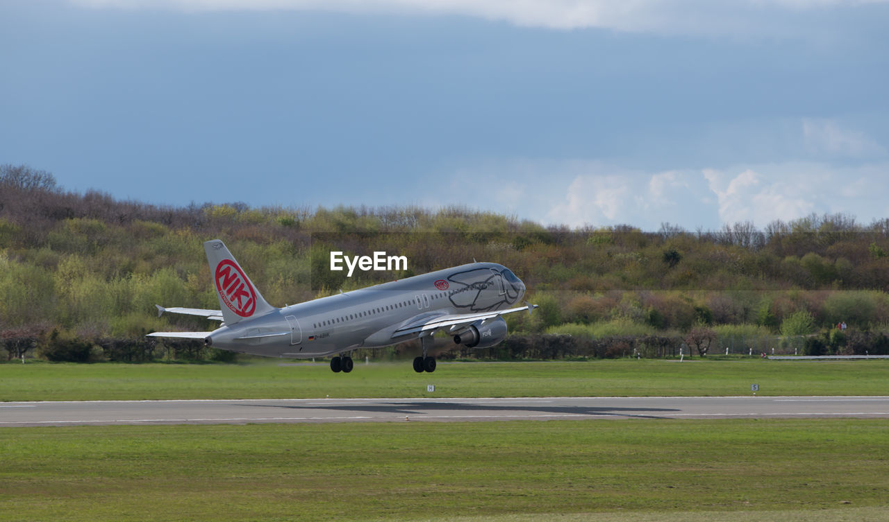 AIRPLANE ON RUNWAY AGAINST SKY