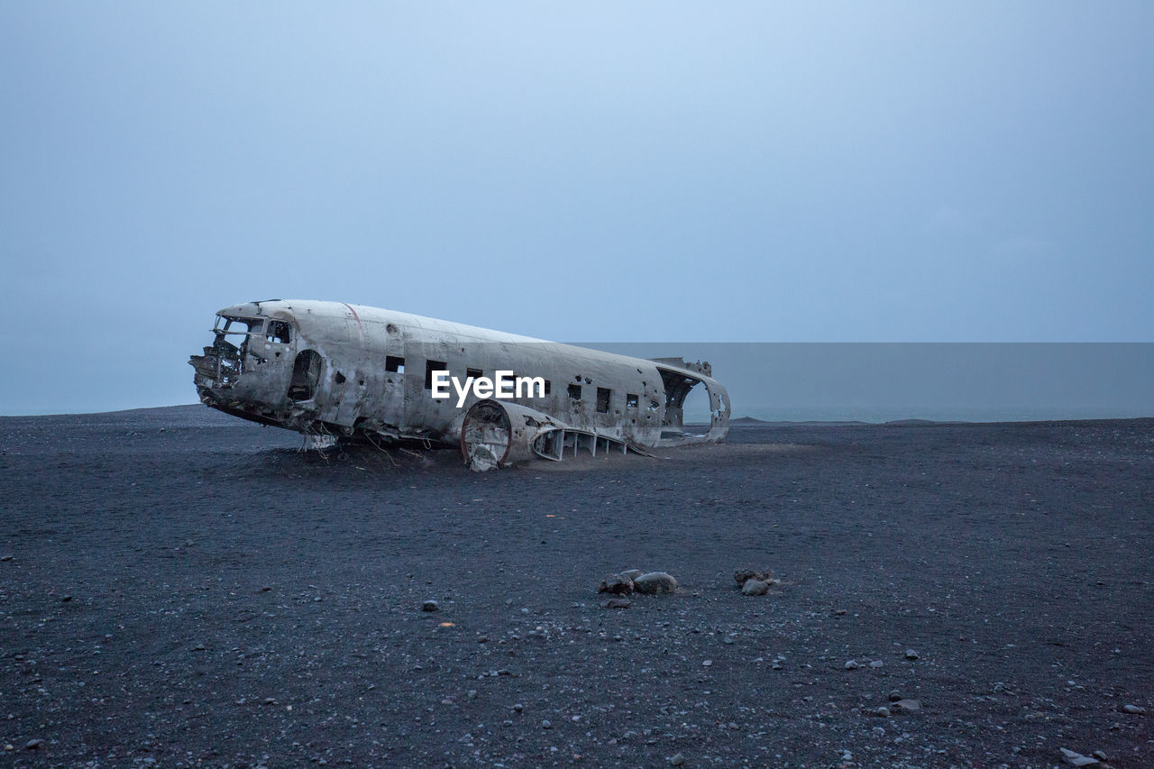 Abandoned airplane at beach against clear sky