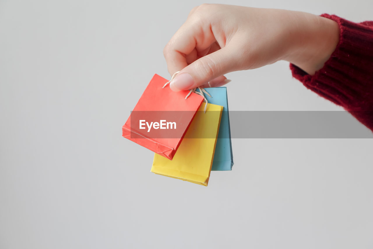 cropped hand of woman holding toy blocks on white background