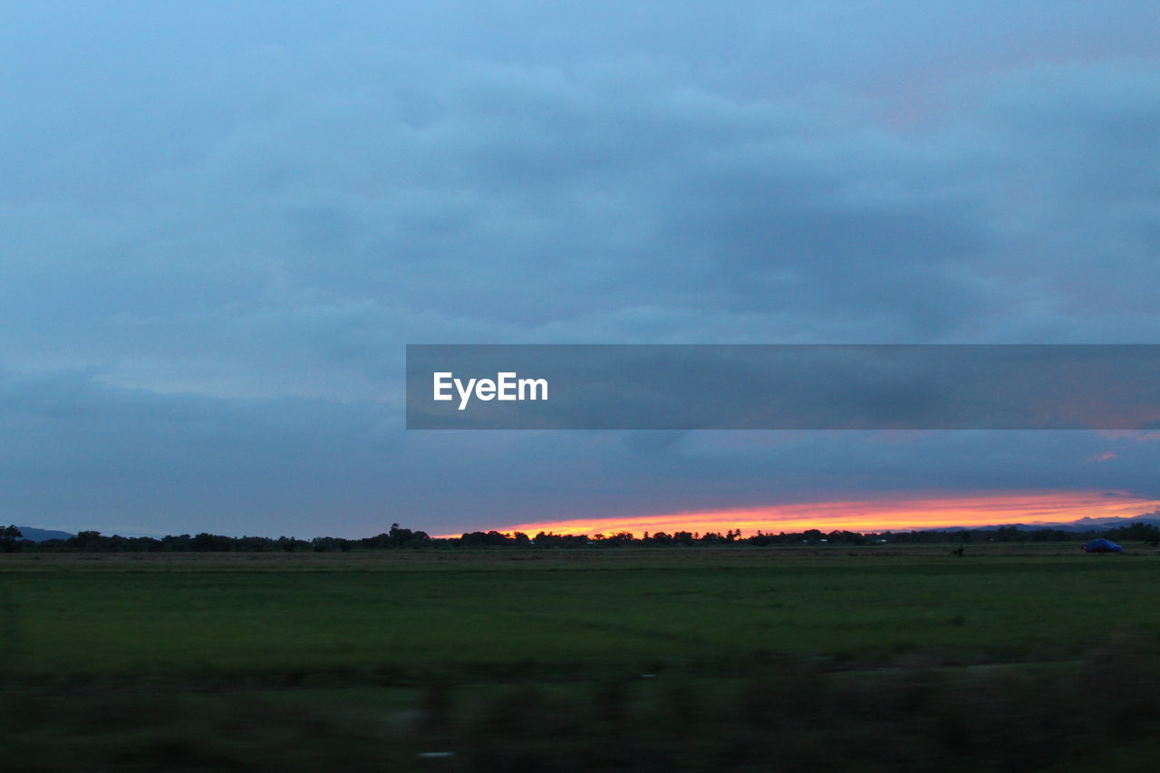 SCENIC VIEW OF LANDSCAPE AGAINST CLOUDY SKY AT SUNSET