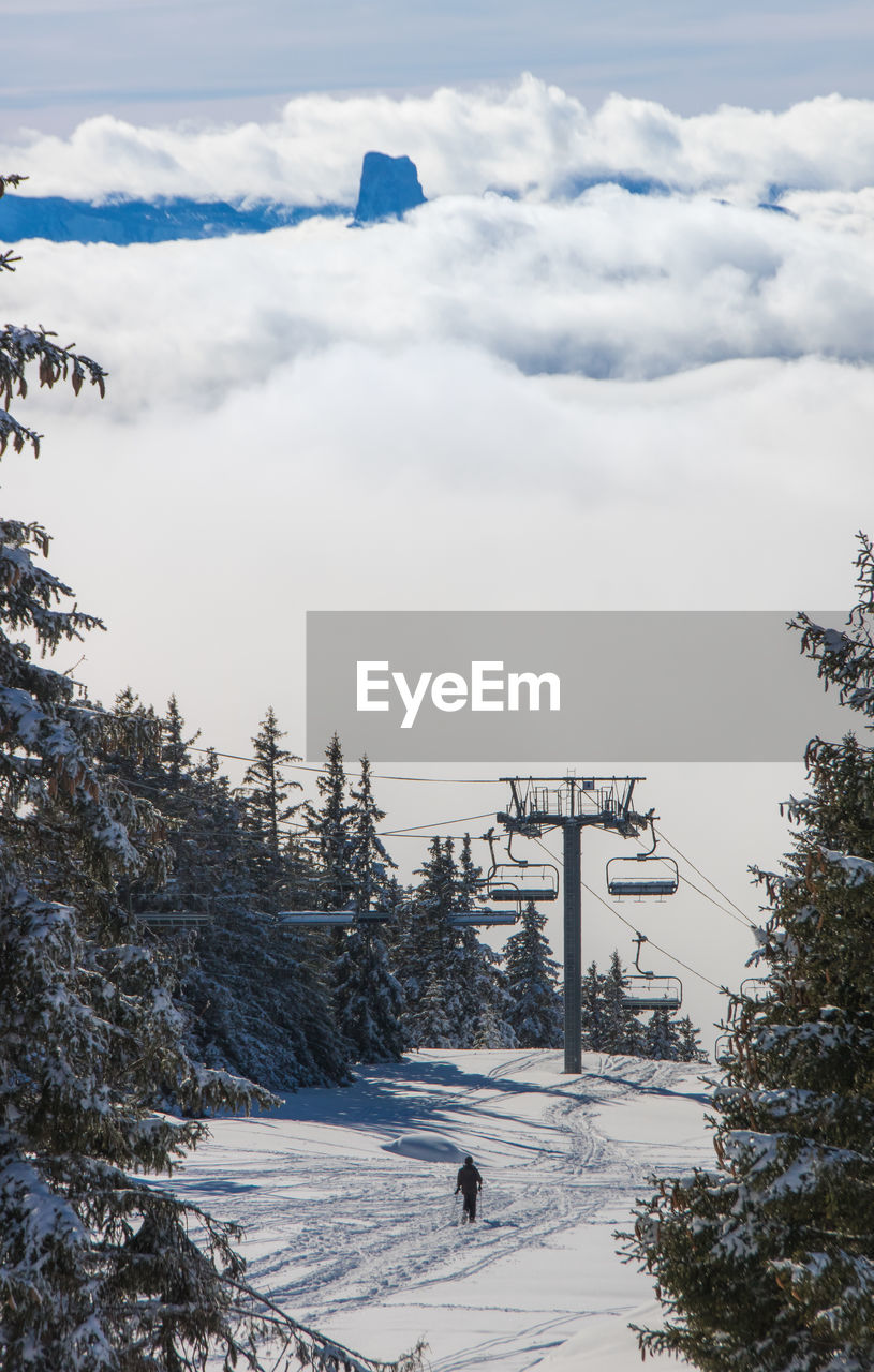 Scenic view of empty ski lift and snow covered mountains against sky