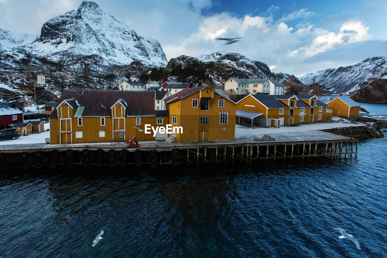 BUILDINGS AGAINST MOUNTAIN RANGE DURING WINTER