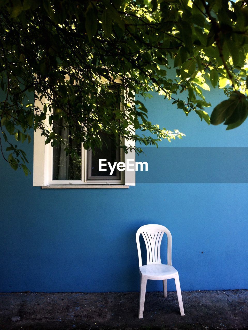 EMPTY CHAIRS AGAINST TREES AND BUILDING