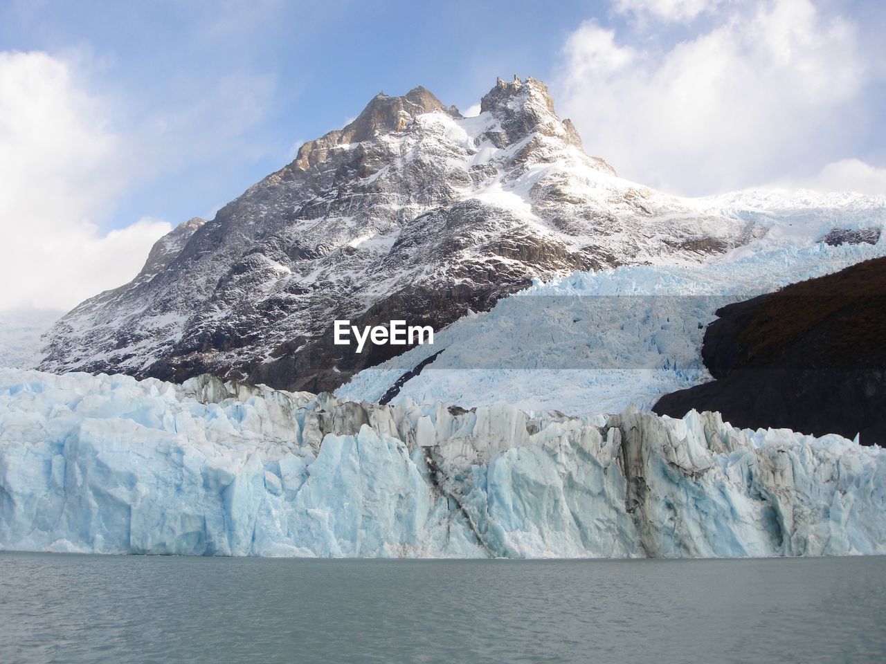 Scenic view of sea and snowcapped mountain against sky