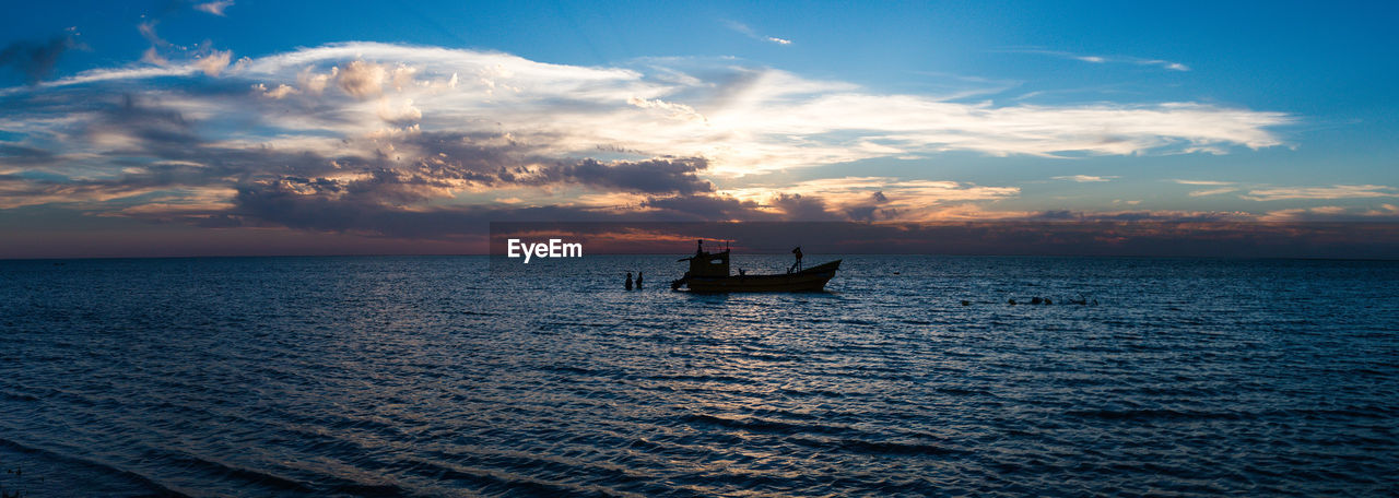 Silhouette boat sailing in sea against sky during sunset