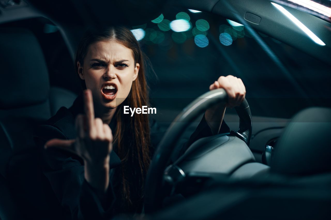 Portrait of woman gesturing sitting in car