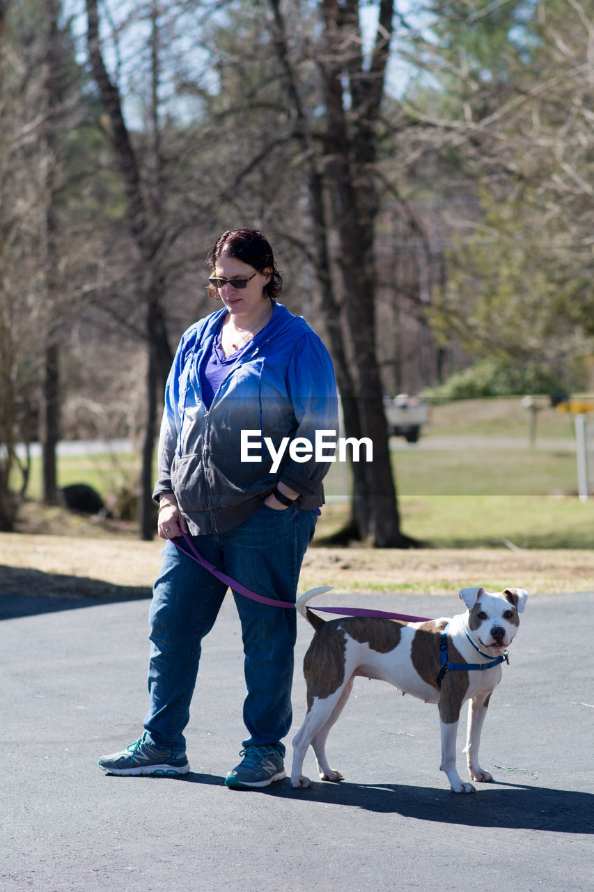 Woman standing with dog on road