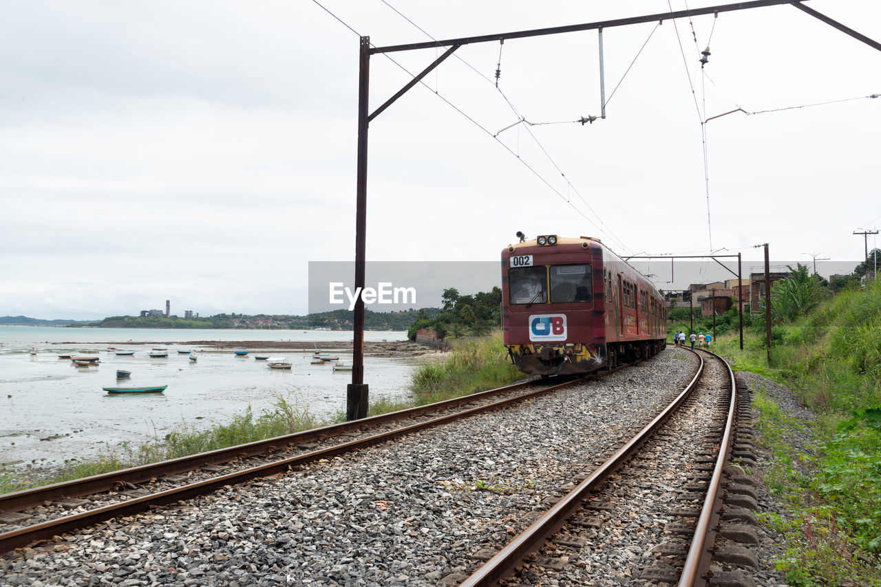 transportation, rail transportation, railroad track, track, mode of transportation, sky, transport, public transportation, train, railway, nature, vehicle, travel, cloud, water, day, no people, electricity, architecture, outdoors, land vehicle, cable, rolling stock, journey, locomotive, motion, travel destinations, railroad car