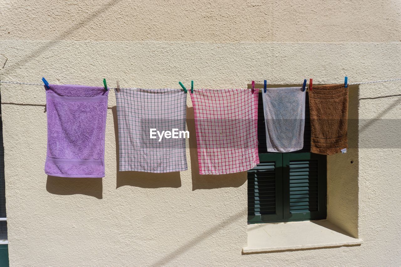 CLOTHES DRYING ON CLOTHESLINE AGAINST BUILDING