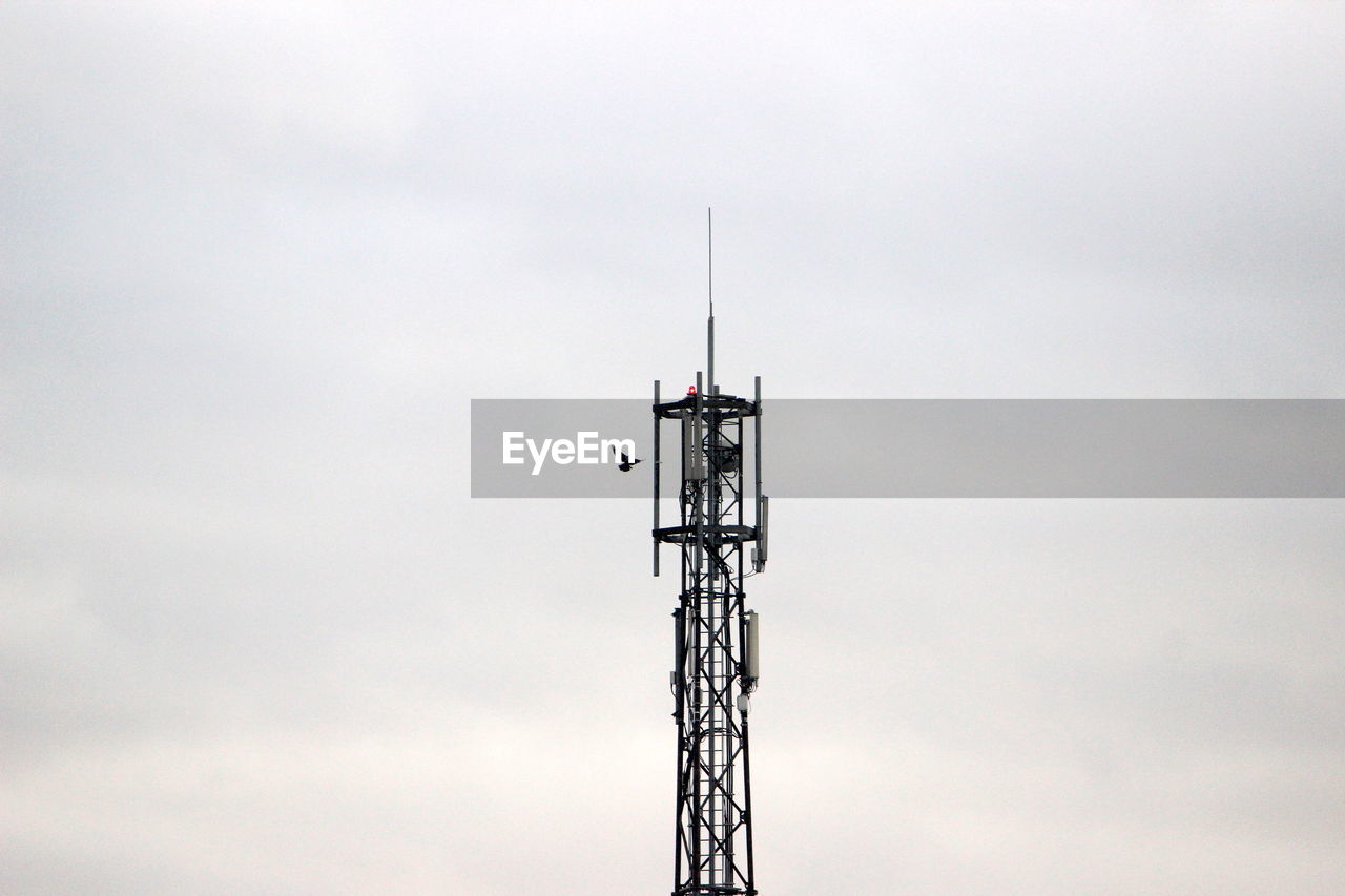 Low angle view of communications tower against sky