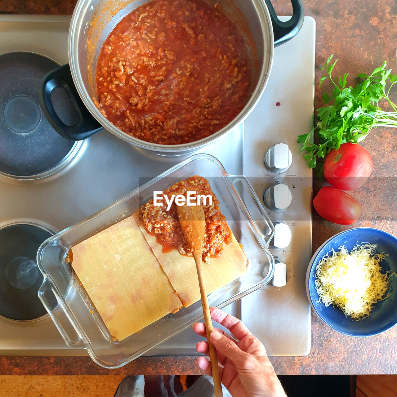 High angle view of person cooking preparing lasagna