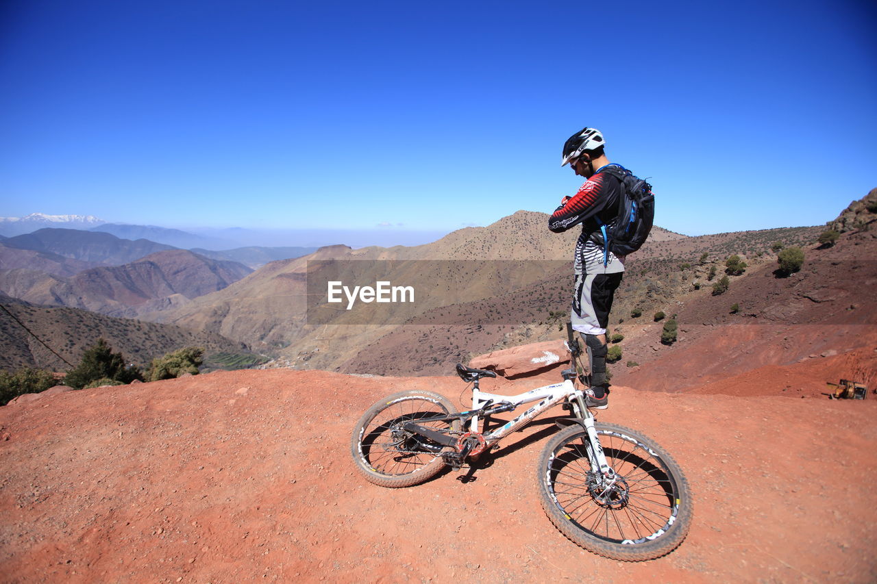 MAN RIDING MOTORCYCLE ON MOUNTAIN