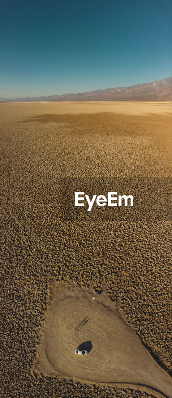 HIGH ANGLE VIEW OF SAND DUNE ON DESERT AGAINST SKY