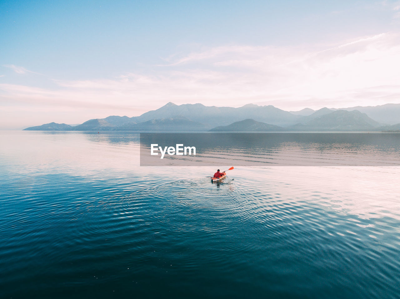 PERSON IN LAKE AGAINST SKY