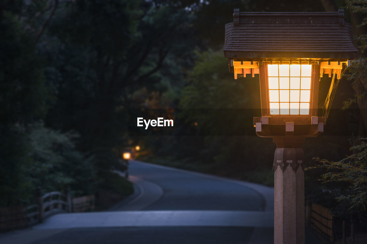 Illuminated street light on road at night