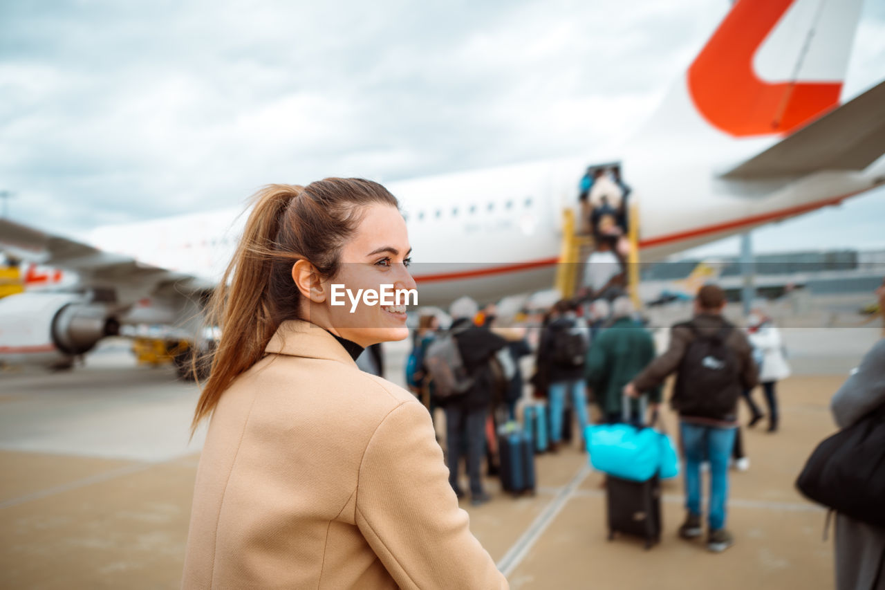 Happy woman walking towards airplane