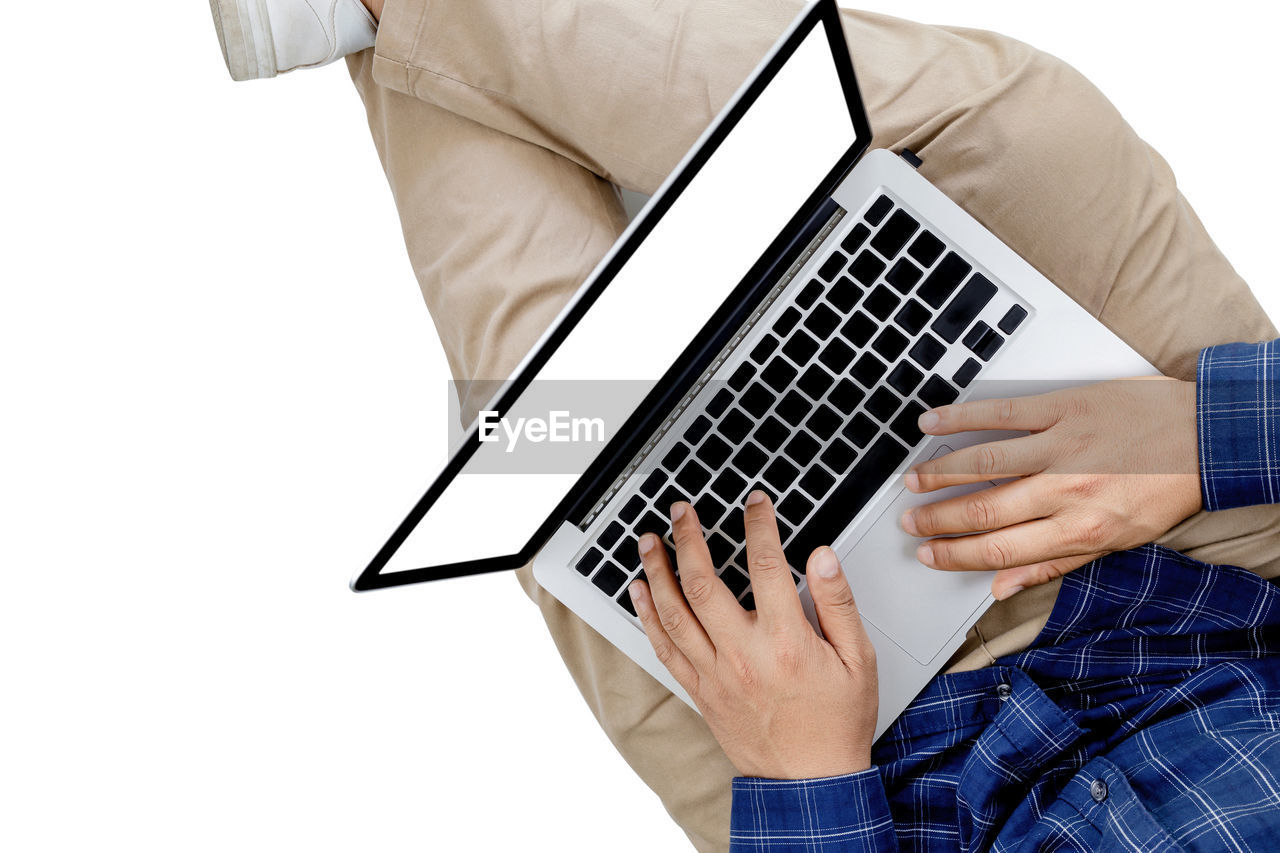 Midsection of man using laptop on white background